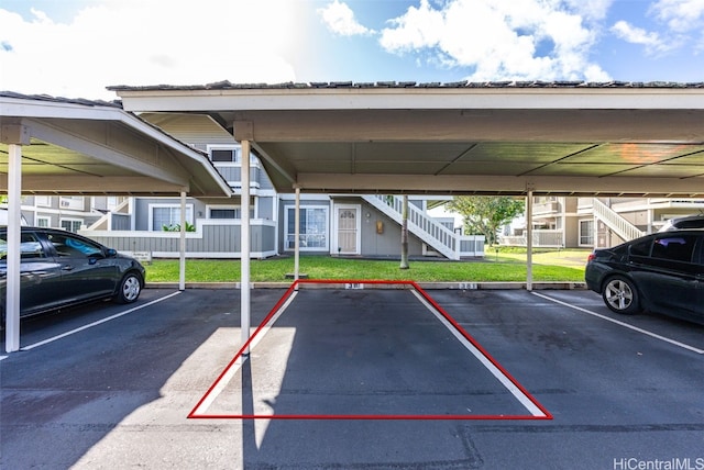 view of parking with a yard and a carport