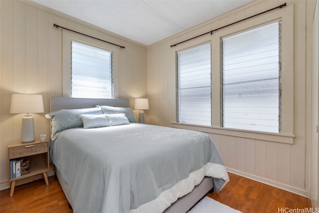 bedroom with wood-type flooring and ornamental molding