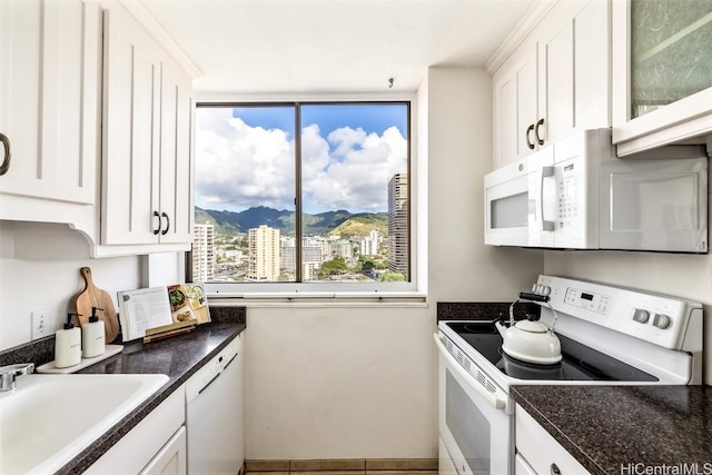 kitchen featuring a mountain view, sink, white cabinets, and white appliances