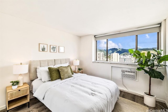 bedroom featuring a wall mounted AC, a mountain view, and dark hardwood / wood-style floors