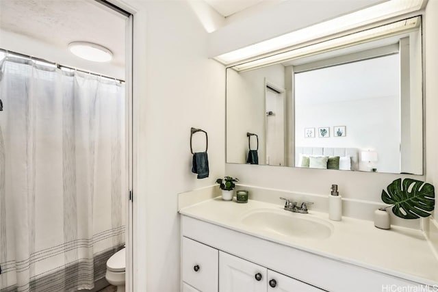 bathroom featuring a shower with curtain, vanity, and toilet