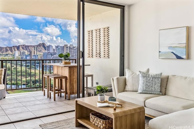 tiled living room featuring a mountain view, plenty of natural light, and expansive windows