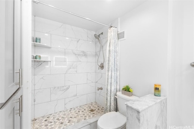 bathroom with toilet and tiled shower