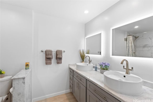 bathroom with toilet, recessed lighting, and a sink