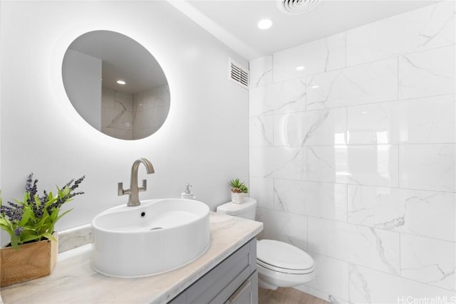 bathroom with recessed lighting, visible vents, toilet, and vanity