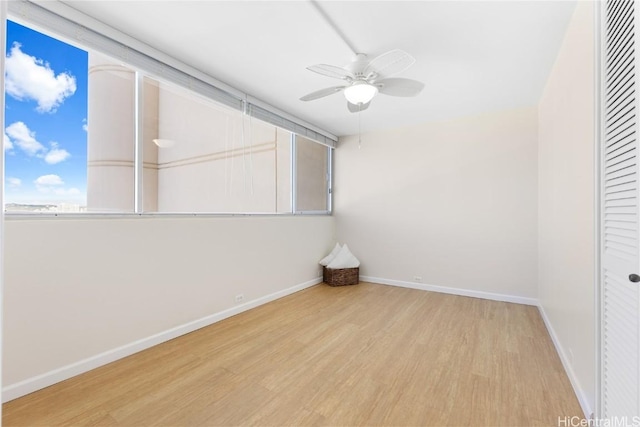 spare room with baseboards, a ceiling fan, and wood finished floors