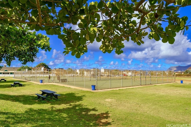 view of community with a yard, a rural view, and tennis court