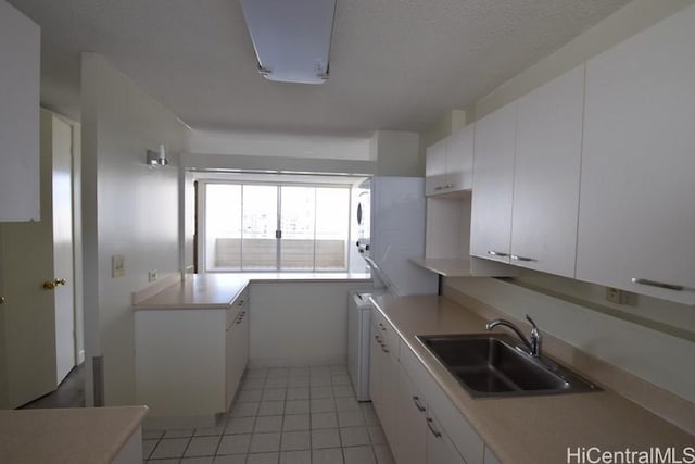 kitchen featuring light tile patterned flooring, white cabinetry, and sink