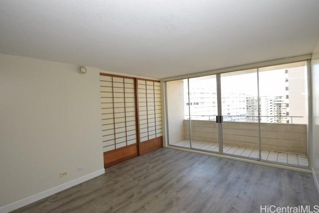 empty room featuring dark hardwood / wood-style flooring and floor to ceiling windows