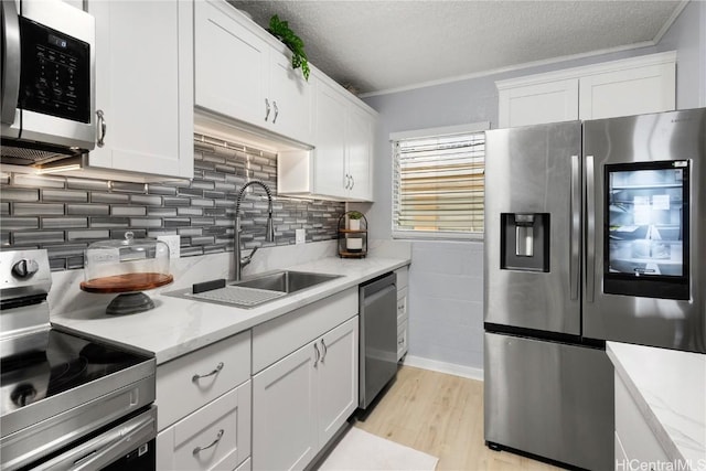 kitchen featuring sink, white cabinets, and appliances with stainless steel finishes