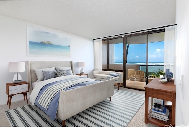 carpeted bedroom featuring access to outside, expansive windows, and a water view