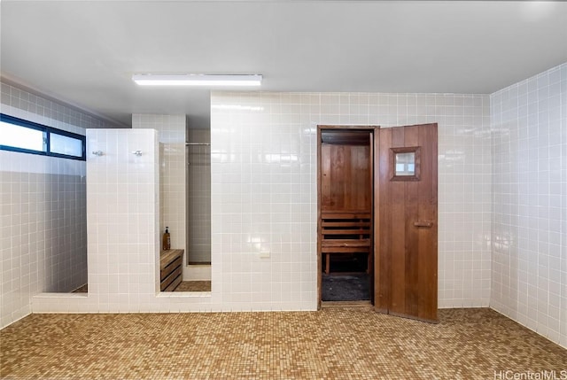 bathroom with a shower and tile walls