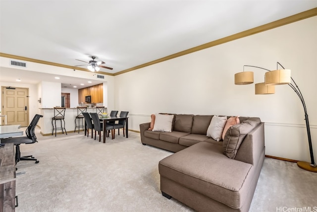 living room featuring light colored carpet, ornamental molding, and ceiling fan