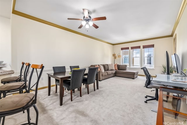 carpeted dining area with ornamental molding and ceiling fan