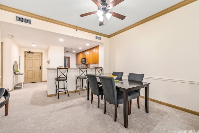 dining room with ornamental molding and light carpet