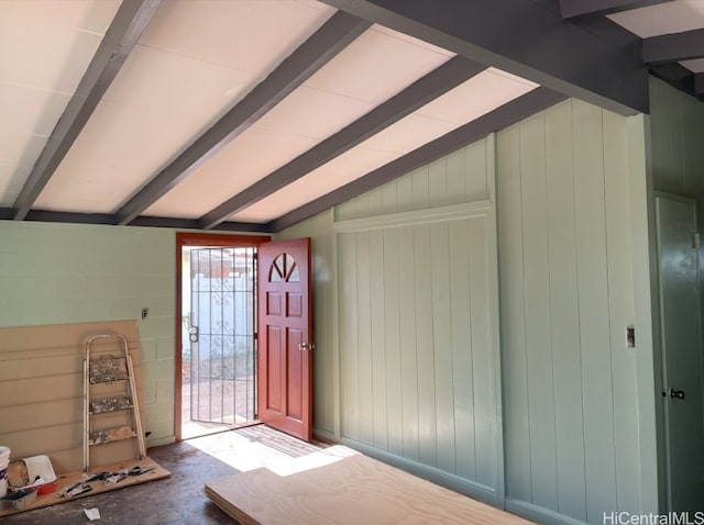 entryway with vaulted ceiling with beams and wooden walls