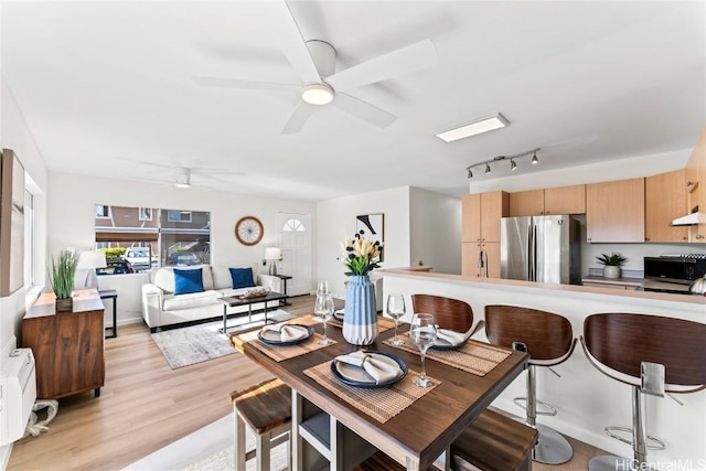 dining area with ceiling fan, rail lighting, and light wood-type flooring