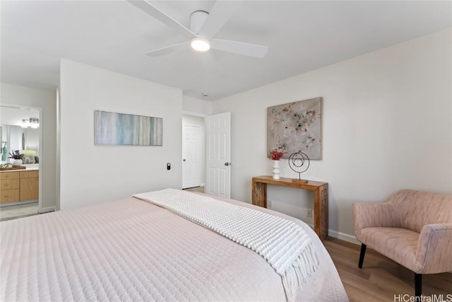 bedroom featuring ceiling fan, ensuite bathroom, and light hardwood / wood-style flooring