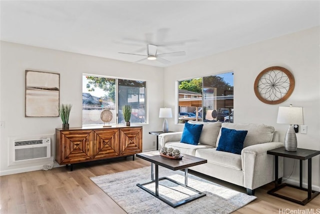 living room with an AC wall unit, ceiling fan, and light wood-type flooring