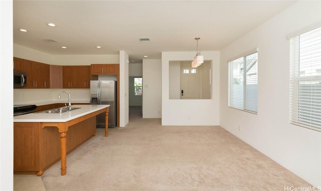 kitchen with pendant lighting, a breakfast bar, light carpet, sink, and appliances with stainless steel finishes