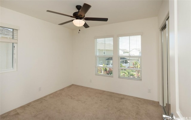 unfurnished room with light carpet and ceiling fan