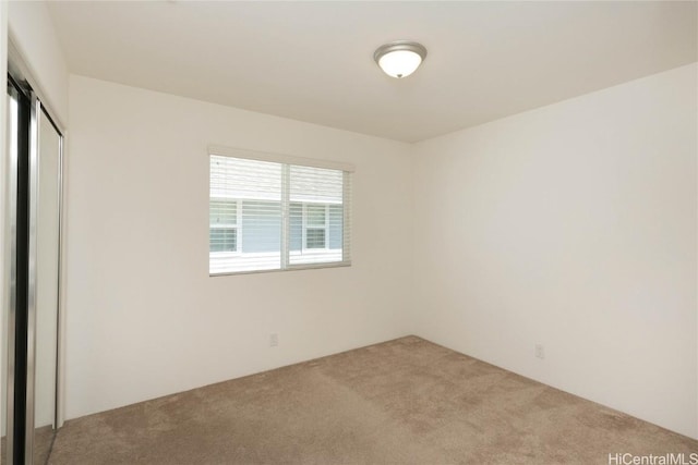 unfurnished bedroom with light carpet and a closet