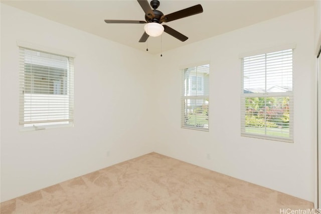 empty room featuring ceiling fan and carpet