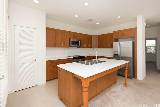 kitchen with sink, a kitchen bar, stainless steel appliances, and an island with sink