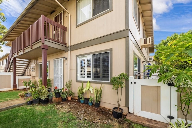 entrance to property featuring a gate, fence, and a balcony