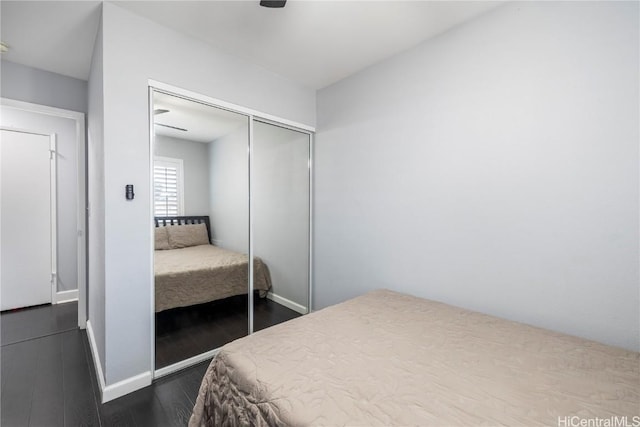 bedroom featuring dark hardwood / wood-style flooring, a closet, and ceiling fan