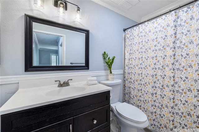 bathroom with vanity, ornamental molding, and toilet