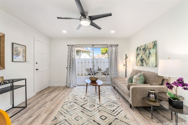 living room featuring ceiling fan and light hardwood / wood-style floors