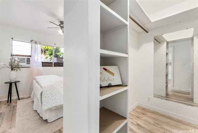 spacious closet featuring light hardwood / wood-style floors, ceiling fan, and cooling unit