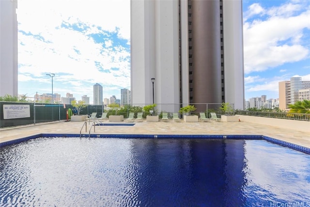 view of swimming pool with a water view and a patio