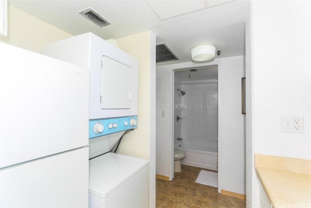 full bathroom featuring toilet, vanity, stacked washer / drying machine, and washtub / shower combination