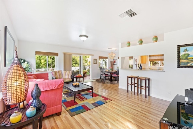 living room featuring a notable chandelier, wood-type flooring, and sink