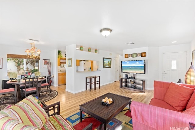 living room featuring a notable chandelier and light hardwood / wood-style floors