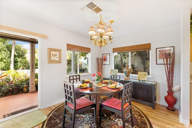 dining space featuring light hardwood / wood-style floors and an inviting chandelier