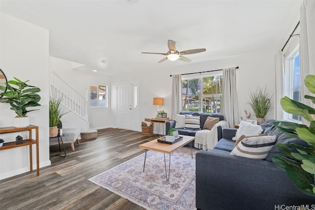 living room featuring dark wood-type flooring and ceiling fan