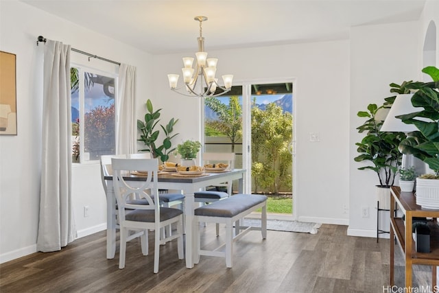 dining area featuring a notable chandelier, dark wood-type flooring, and a wealth of natural light