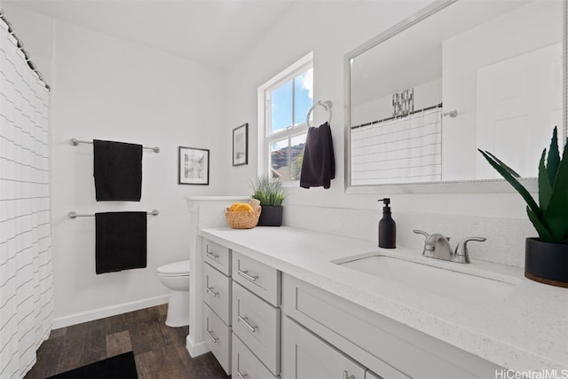 bathroom with vanity, toilet, and hardwood / wood-style floors