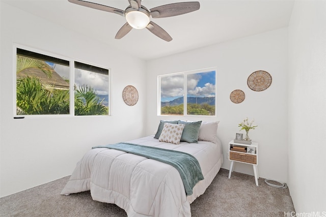 bedroom with multiple windows, light colored carpet, and ceiling fan