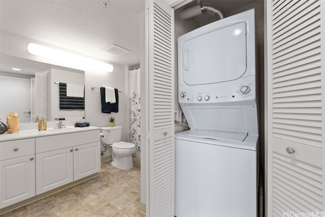 laundry area featuring sink and stacked washer / dryer