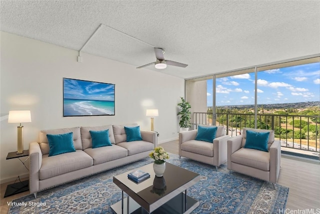 living room with hardwood / wood-style floors, ceiling fan, floor to ceiling windows, and a textured ceiling