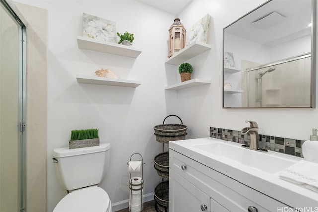 bathroom featuring toilet, decorative backsplash, a shower with shower door, and vanity