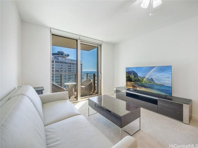 living room with ceiling fan and a wall of windows