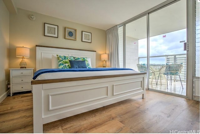 bedroom with access to exterior and light wood-type flooring