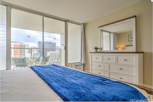 bedroom with access to exterior, an AC wall unit, and a wall of windows