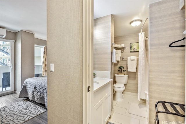 bathroom featuring a wall mounted air conditioner, vanity, toilet, and tile patterned flooring