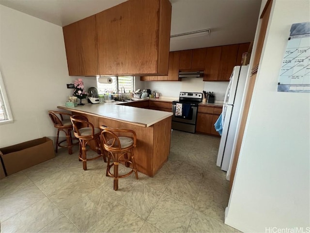 kitchen featuring extractor fan, stainless steel range with electric cooktop, white refrigerator, kitchen peninsula, and a breakfast bar